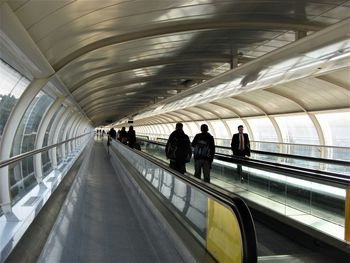 Rear view of people walking in subway station