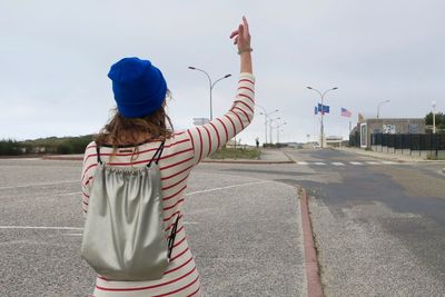 Rear view of girl standing against sky