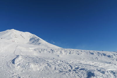 Scenic view of snowcapped mountains against clear blue sky