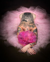 Full length of woman with pink hair against black background