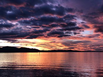 Scenic view of sea against dramatic sky during sunset