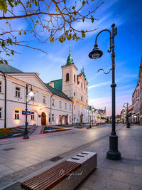 Street amidst buildings against blue sky