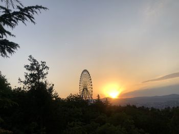 Silhouette of ferris wheel during sunset