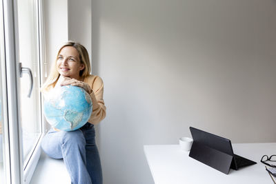 Young woman using laptop while sitting on sofa at home