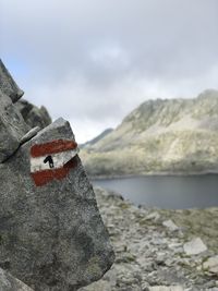 Close-up of snow on rock against sky