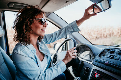 Side view of woman sitting driving car