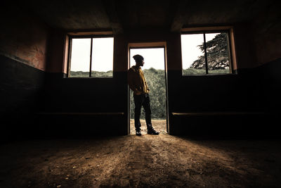 Man standing in doorway of abandoned home