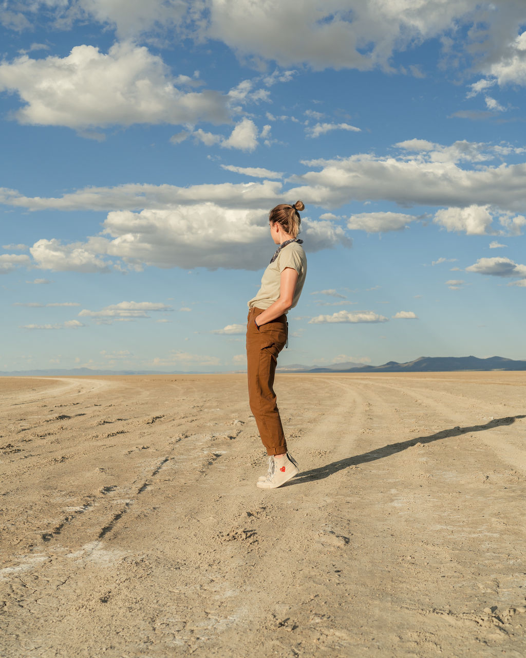sky, cloud - sky, land, one person, full length, desert, leisure activity, real people, scenics - nature, lifestyles, environment, sand, nature, day, landscape, beauty in nature, tranquil scene, non-urban scene, young adult, tranquility, climate, arid climate, outdoors