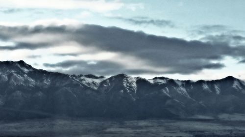 Scenic view of mountains against cloudy sky