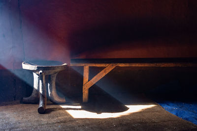 Empty chair on table against wall