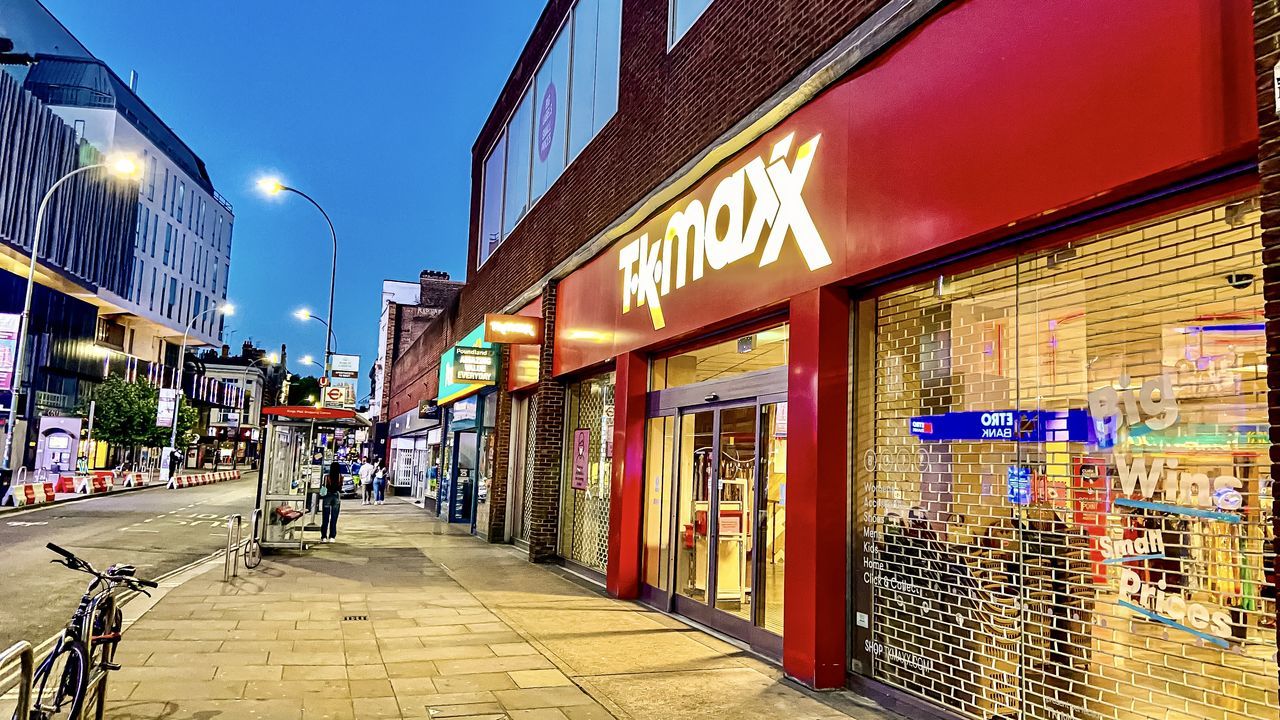 architecture, building exterior, built structure, city, street, illuminated, footpath, incidental people, text, direction, store, communication, the way forward, building, sidewalk, lighting equipment, night, outdoors, sign, transportation