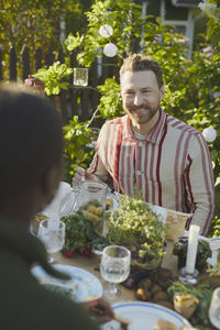 Smiling man at table in garden