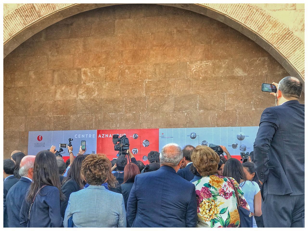 REAR VIEW OF PEOPLE STANDING ON WALL