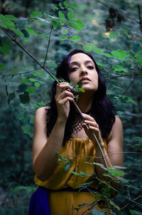 Portrait of young woman holding plant