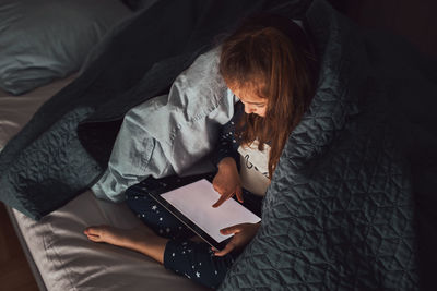 Little girl having fun watching, playing and listening to stories on tablet computer