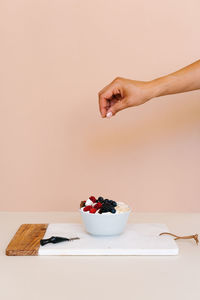 Midsection of woman having food against white background