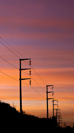 Silhouette electricity pylon against romantic sky at sunset