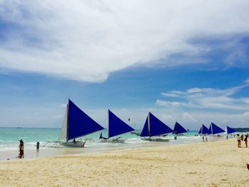 Scenic view of beach against cloudy sky