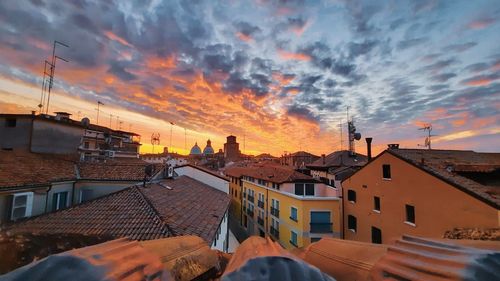 Buildings in town against sky during sunset