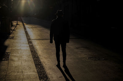 Silhouette of adult man in hat on street during sunset. madrid, spain