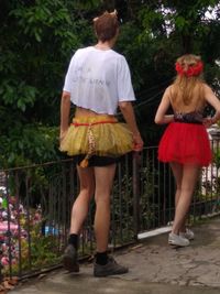 Rear view of friends standing against plants