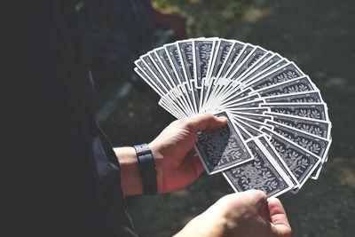 Midsection of man holding cards