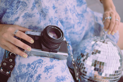 Midsection of woman holding camera