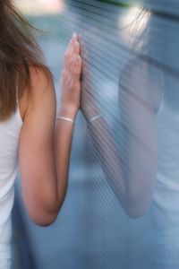 Midsection of woman standing by glass window