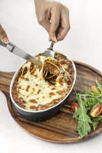 Cropped hand of person preparing food on table