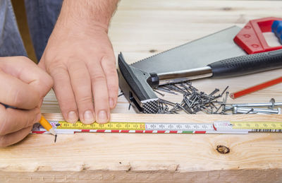 Cropped image of carpenter marking on wood