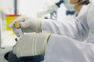 Cropped hands of scientist holding equipment at laboratory