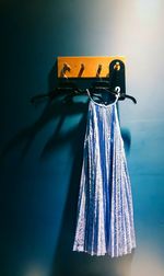 Blue dress hanging on coathanger from hook on wall
