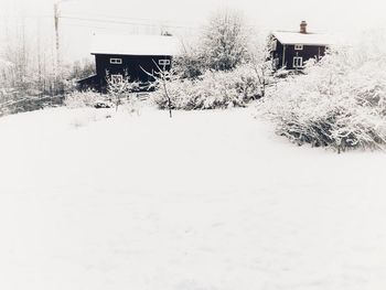 Snow covered field by building