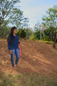 Full length of woman standing on field against sky