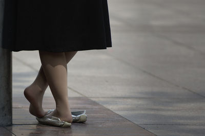 Low section of woman standing on tiled floor