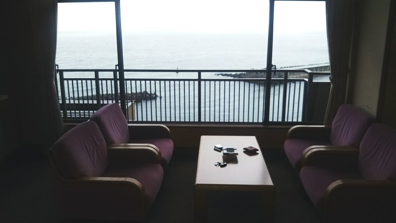 CHAIR AND TABLE BY SEA AGAINST SKY