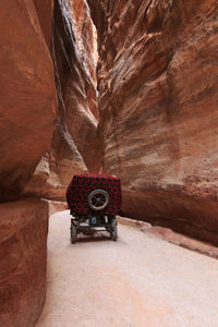 Vehicle moving amidst rock formations at petra