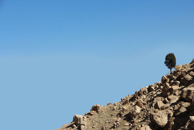 Low angle view of rock formation against clear blue sky