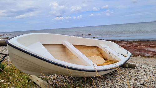 Boat moored on beach against sky