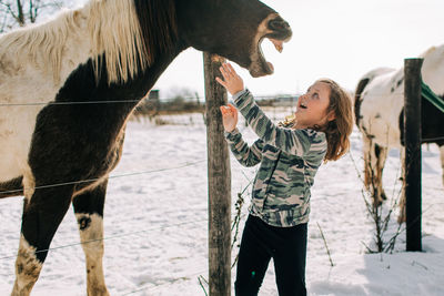 Horse laughing with young girl 
