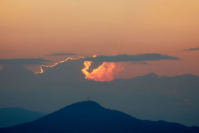 Scenic view of silhouette mountains against romantic sky at sunset