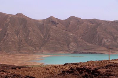 Scenic view of lake and mountains against clear sky
