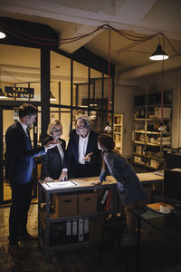 Business people discussing with girl and shining tablet in office