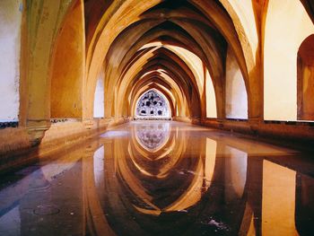 Reflection of ribbed vault on corridor filled with water