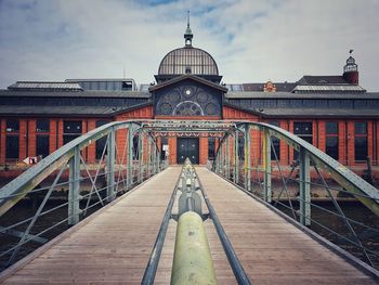 View of footbridge against cloudy sky