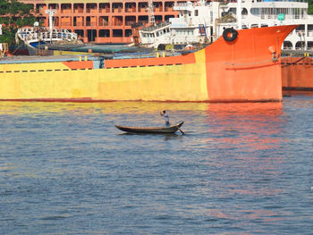 People in boat sailing on sea