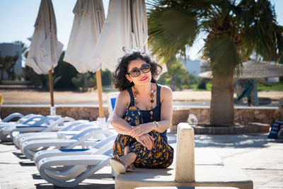 Young woman wearing sunglasses sitting outdoors