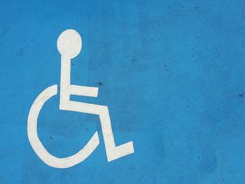 Disabled sign on blue wall