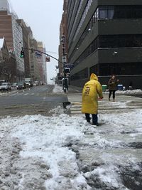 Rear view of people working on snow covered city