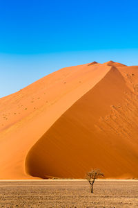 Scenic view of desert against clear blue sky